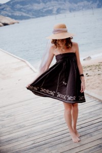 Frau mit schwarzem Bandeau Kleid am Meer